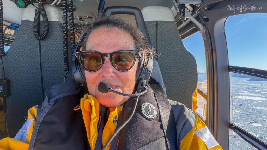 Passenger wearing headset inside helicopter flying over Antarctica