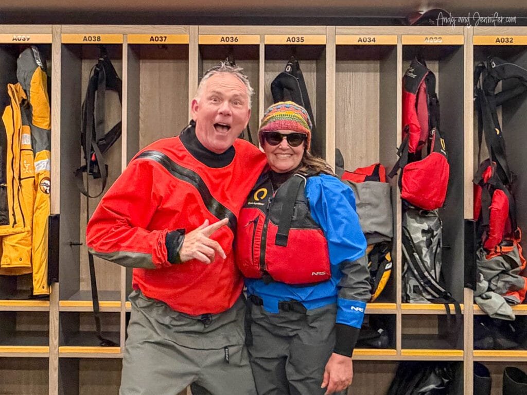 Couple wearing dry suits and life vests in expedition mudroom before Antarctica activities