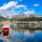 Panoramic view of Ushuaia harbor with expedition cruise ships, calm reflections, and snow-capped mountains in Ushauai, Argentina, after an Antarctica expedition cruise