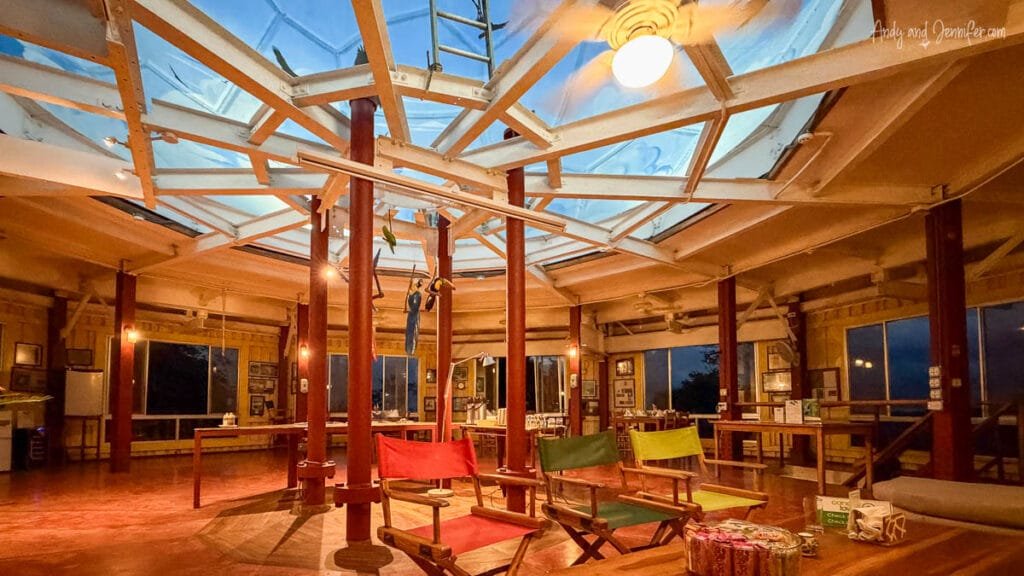 Interior lounge and dining area inside Canopy Tower in Panama, with panoramic rainforest views and the observation deck ladder rising through the center of the former radar station