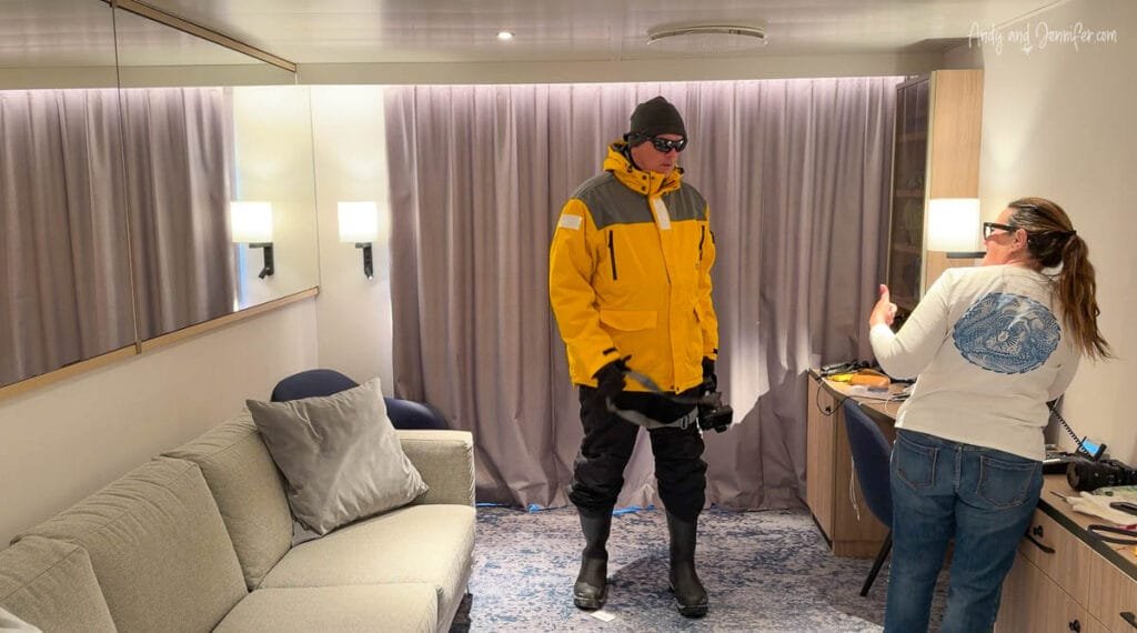 Person dressed in full Antarctica expedition layers being photographed inside ship cabin
