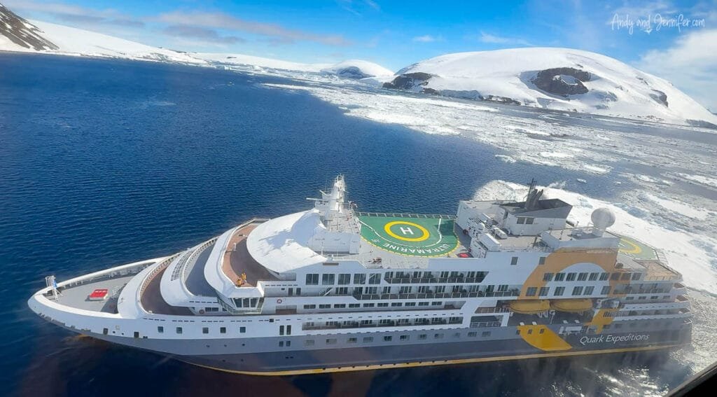 Aerial view of Quark Ultramarine expedition ship with Antarctic mountains in background