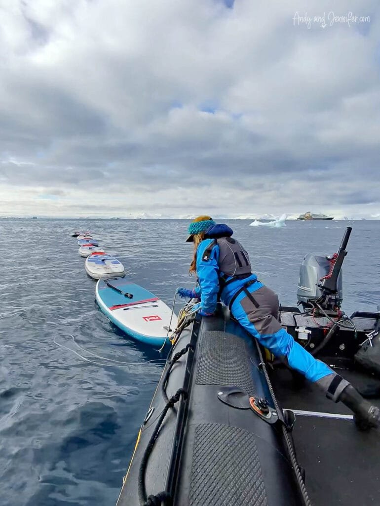 Guide preparing inflatable stand up paddleboards beside a Zodiac in Antarctica near Tower Island during an Antarctic Peninsula expedition