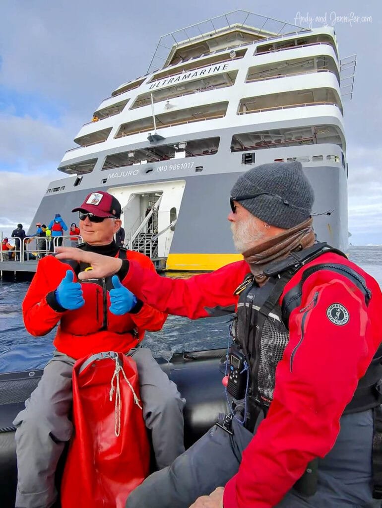 Passenger in dry suit riding a Zodiac beside the Quark Ultramarine before stand up paddleboarding in Antarctica near Tower Island