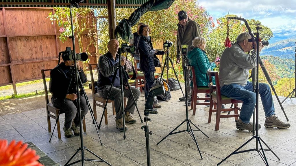 Guide explaining the hummingbird flash photography setup to photographers at Paraíso Quetzales in the Savegre Valley, Costa Rica.