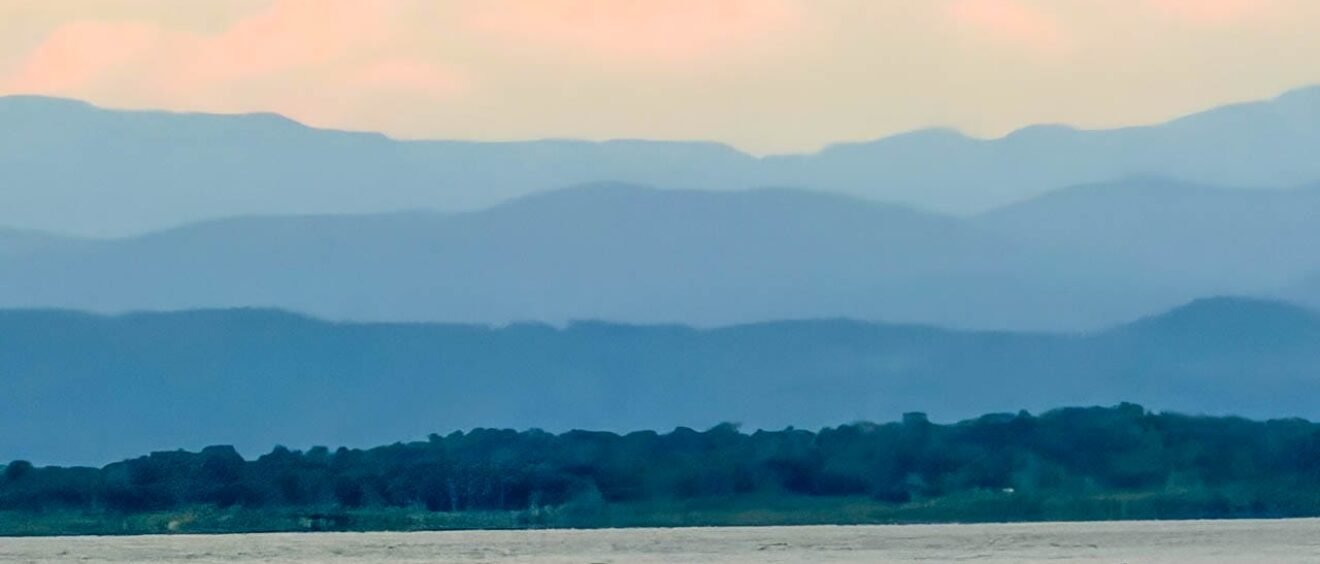 Layered mountain ridges beyond forest and water in western Panama near Bocas del Toro.