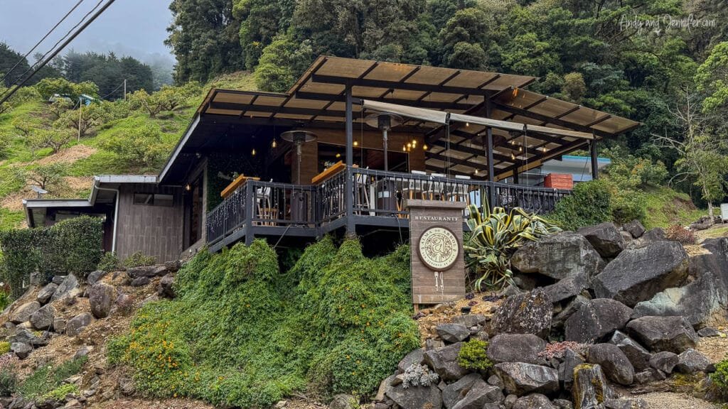 Exterior of Alma del Árbol, a modern mountainside restaurant surrounded by lush forest in the Costa Rican highlands.