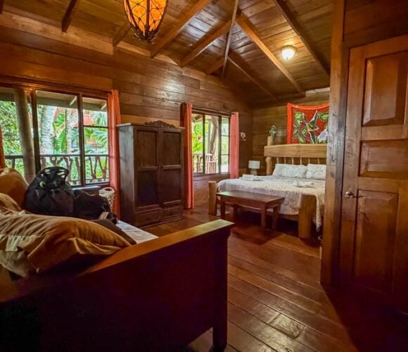 Wooden guest room with a king bed and sitting area at Rancho Naturalista in Costa Rica.