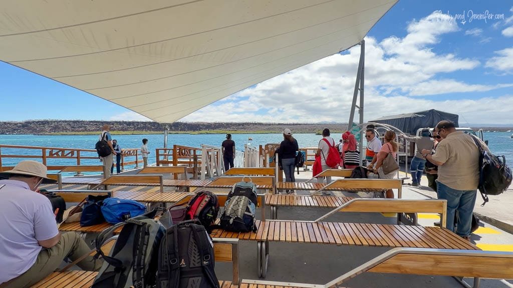 Passengers and luggage waiting at the ferry dock on Baltra Island before crossing to Santa Cruz in the Galápagos.