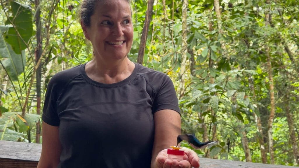 Jennifer hand-feeding a hummingbird at a rainforest visitor center near Canopy Tower Panama in Soberanía National Park.