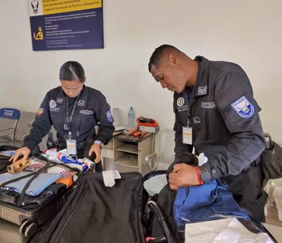 Ecuadorian police officers inspecting passengers’ luggage during a security check at an airport in Ecuador.