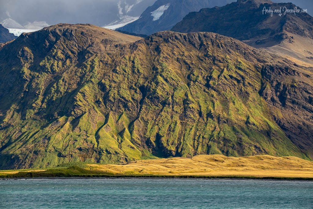 Sunlit mountains rising above the coastline at Stromness, South Georgia.