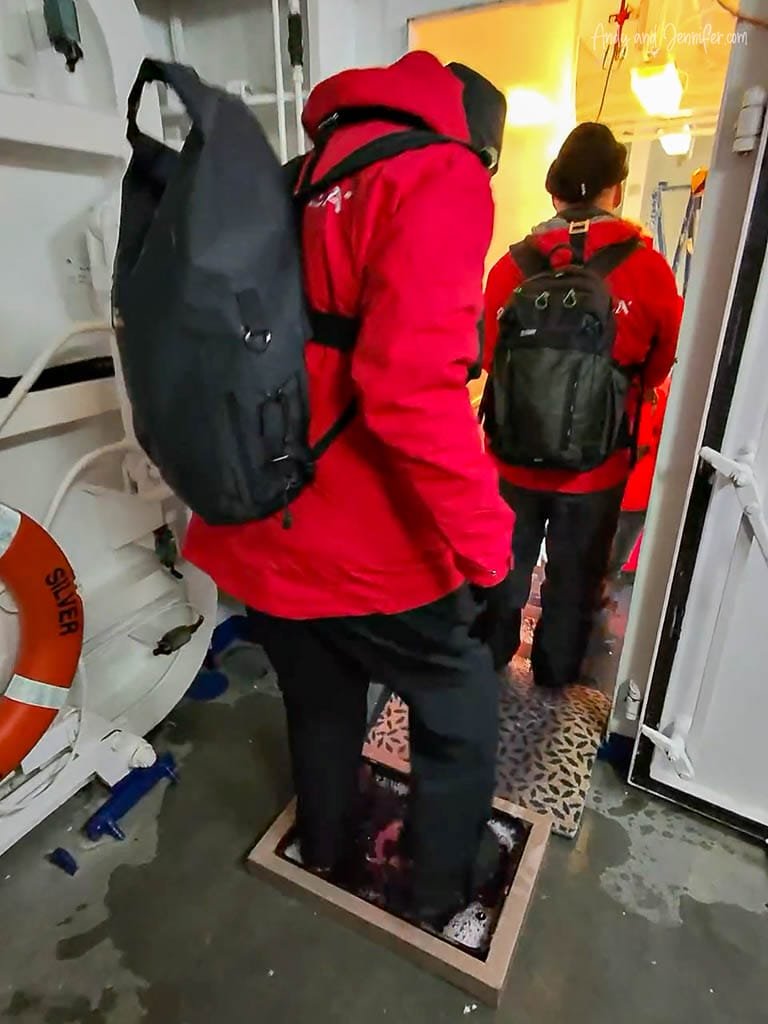 Passengers disinfecting expedition boots before leaving Silver Wind for a shore landing.