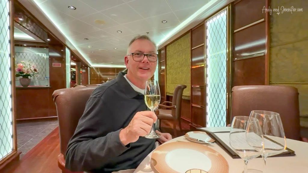 Andy holding a glass of champagne at dinner aboard Silver Wind during the expedition cruise.