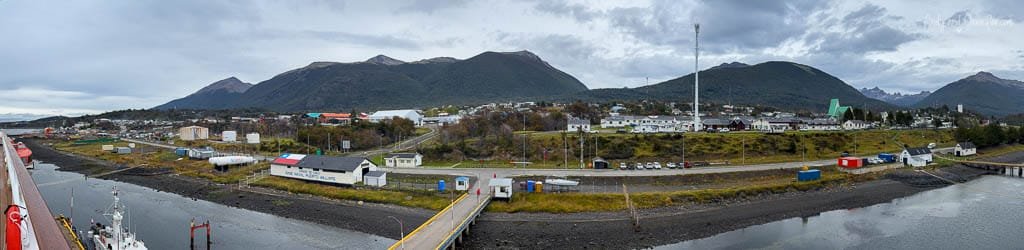 Panoramic view of Puerto Williams, Chile, from the waterfront, with the town and mountains of Isla Navarino under cloudy skies.
