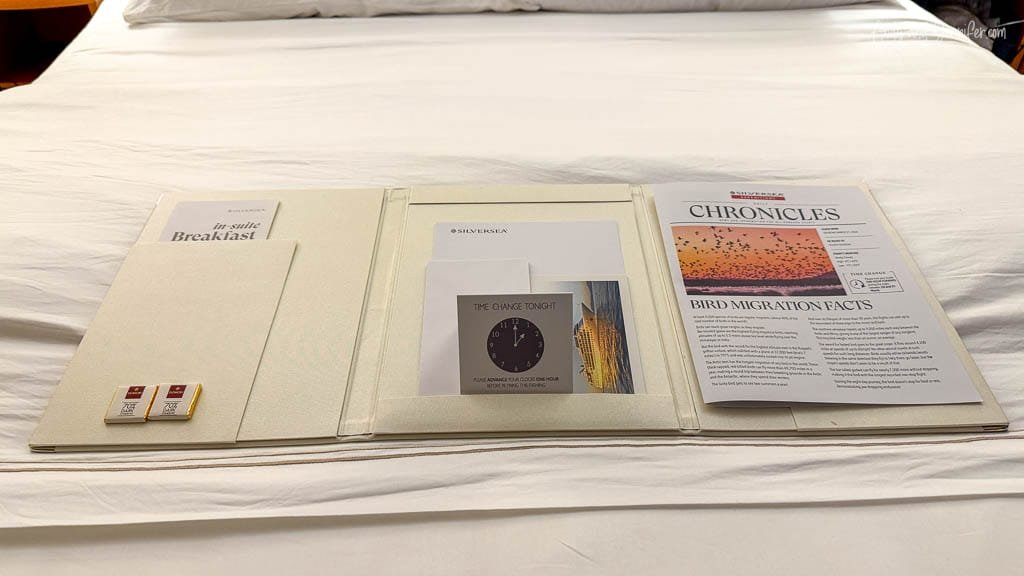 Daily Silversea newsletter, time-change notice and chocolates left on the bed during evening turndown service aboard Silver Wind.