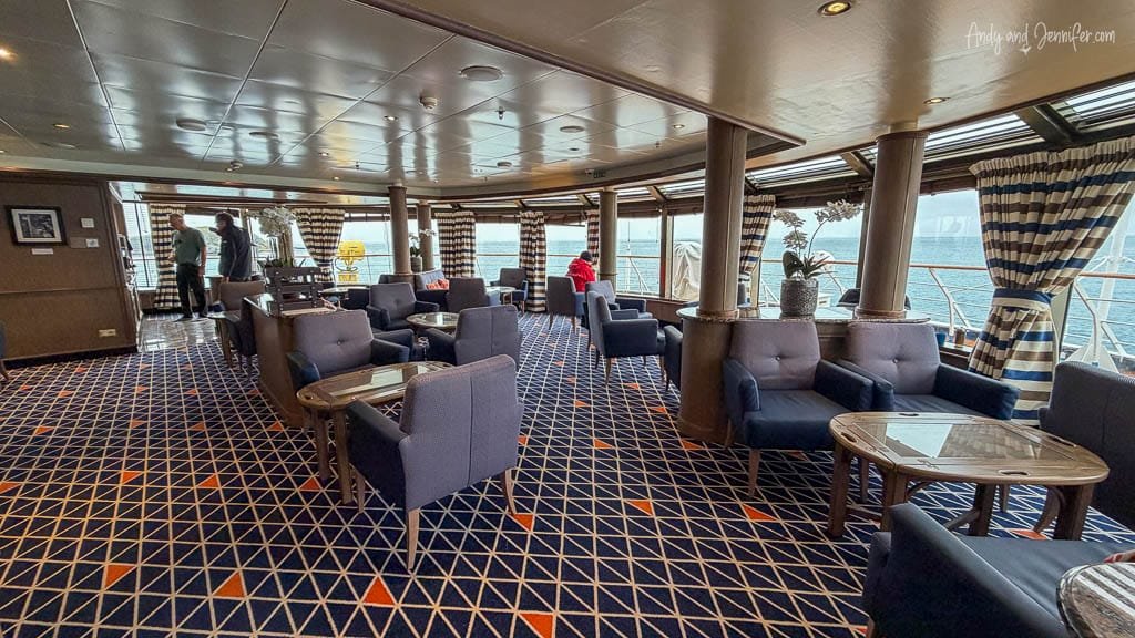 Observation Lounge aboard Silver Wind, with armchairs and large windows overlooking the ocean.