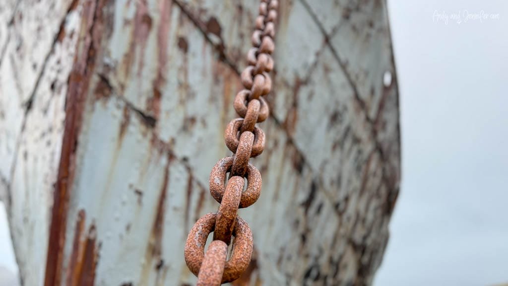 Rusted chain hanging against weathered industrial equipment at the former Grytviken whaling station, South Georgia.
