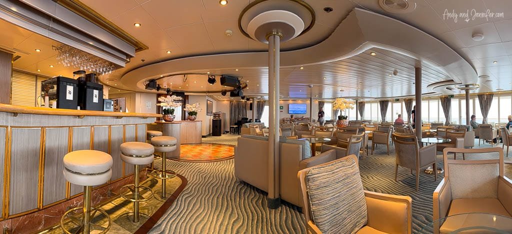 Panorama Lounge aboard Silver Wind, with bar seating and lounge chairs overlooking the ocean through large windows.