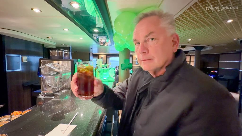Andy holding a drink at the bar during a St Patrick’s Day celebration aboard Silver Wind.