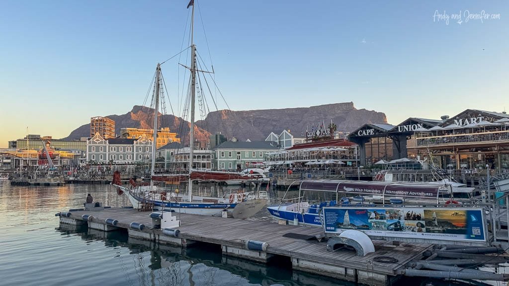 V&A Waterfront marina in Cape Town with Table Mountain rising behind the harbour at sunset.