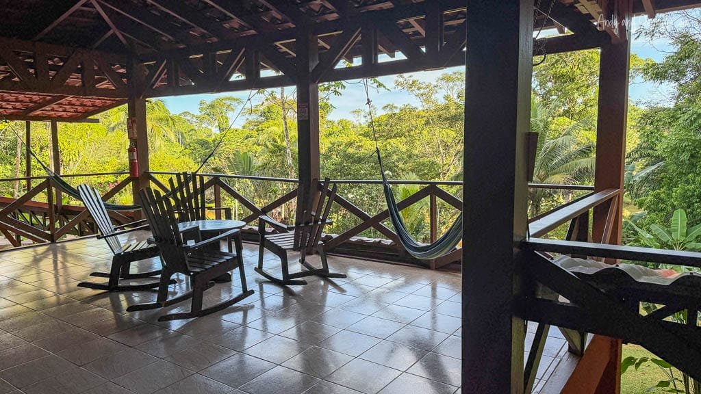 Open-air terrace with rocking chairs and hammocks overlooking the rainforest at Laguna del Lagarto in Costa Rica.