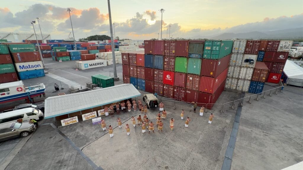Cultural performance amongst shipping containers at the port of Apia, Samoa